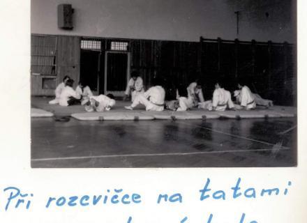 Při rozcvičce na tatami ve sportovní hale